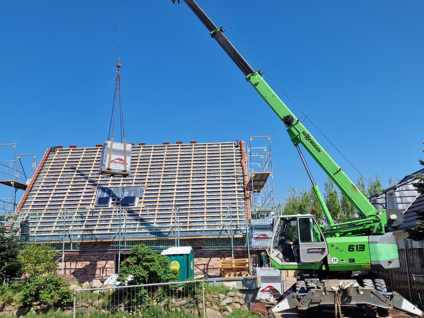 Kran hebt Dämmung auf ein Dach im Umbau