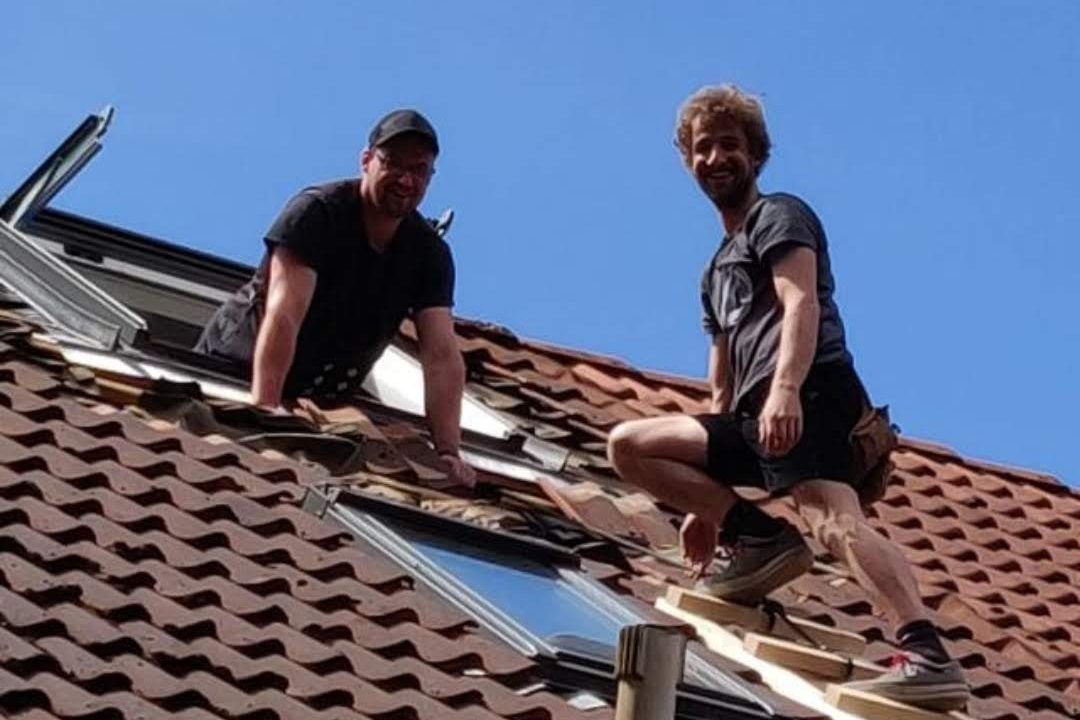 Tim Tüchsen mit Kollege auf dem Dach beim Einbau eines Dachfensters