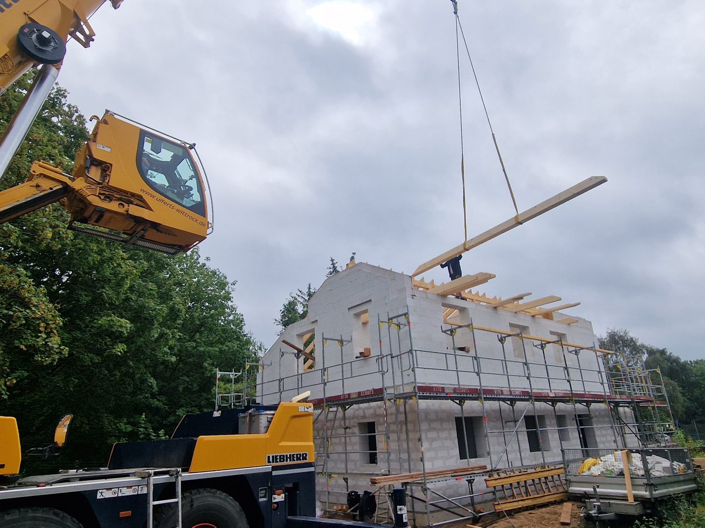 Holzrahmenbau-Elemente werden per Kran auf ein Haus gehoben